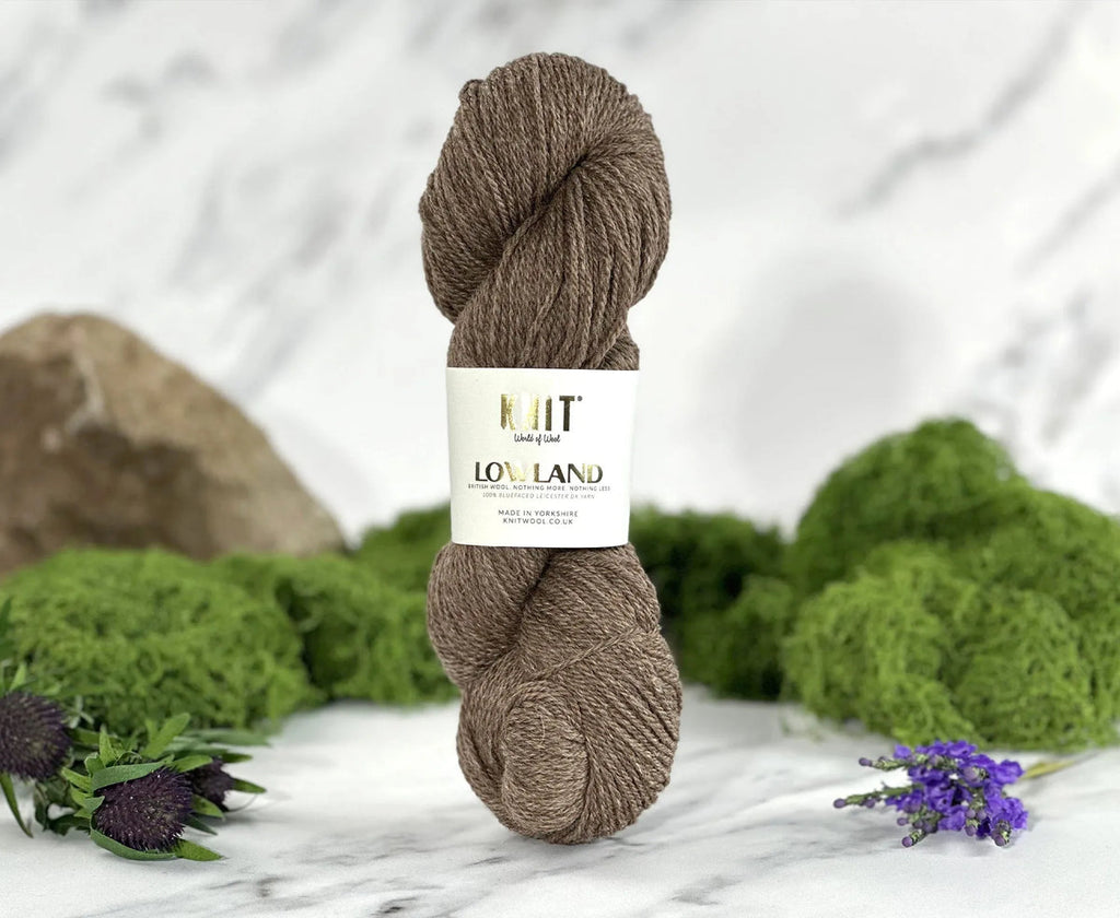 Ball of yarn with a label on a marble surface with greenery in the background