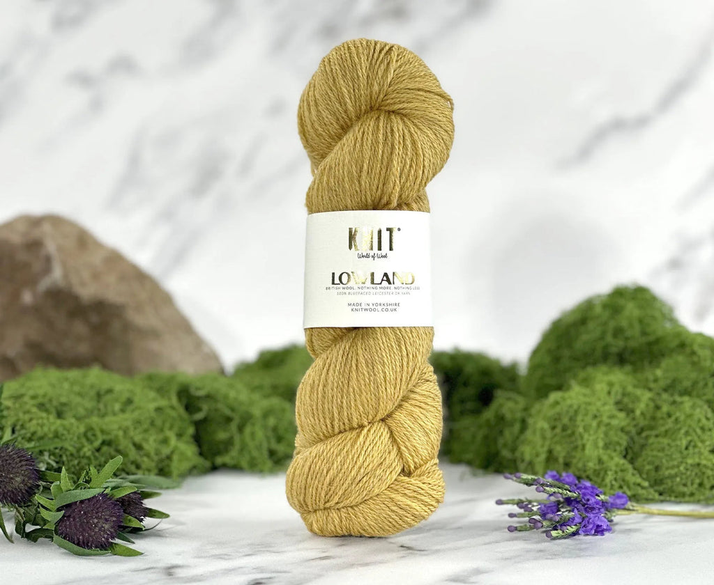 Ball of yarn with a label on a marble surface surrounded by greenery