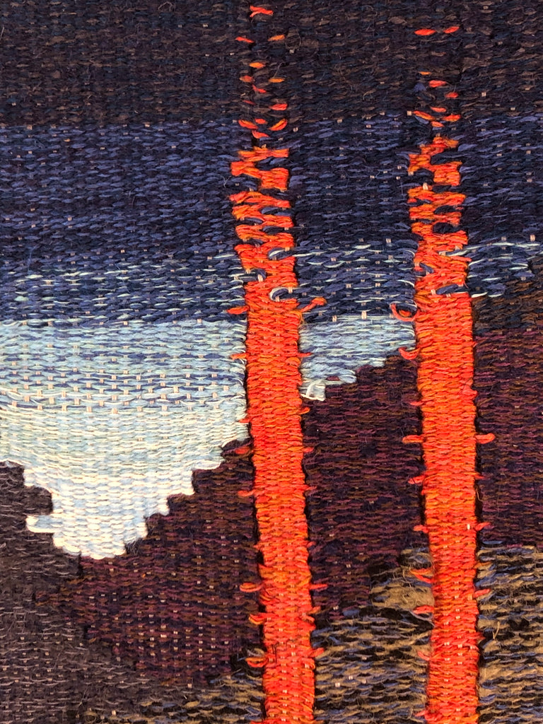 Close-up of woven fabric with red, blue, and brown colors.