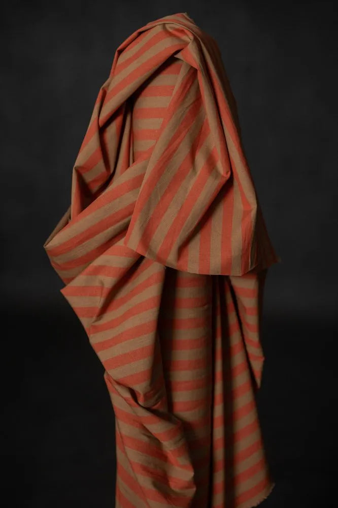 Orange and brown striped fabric draped over a dark background