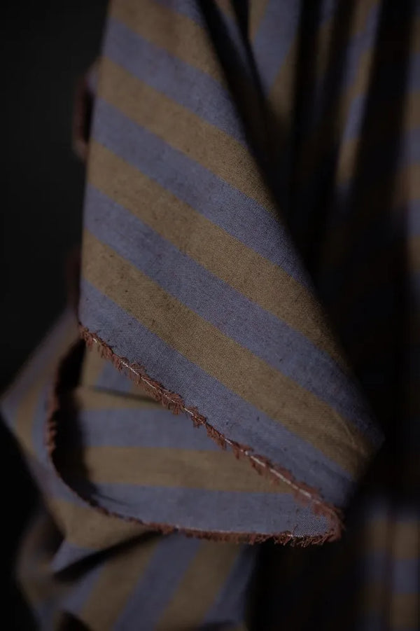 Close-up of a folded fabric with blue and yellow stripes on a dark background