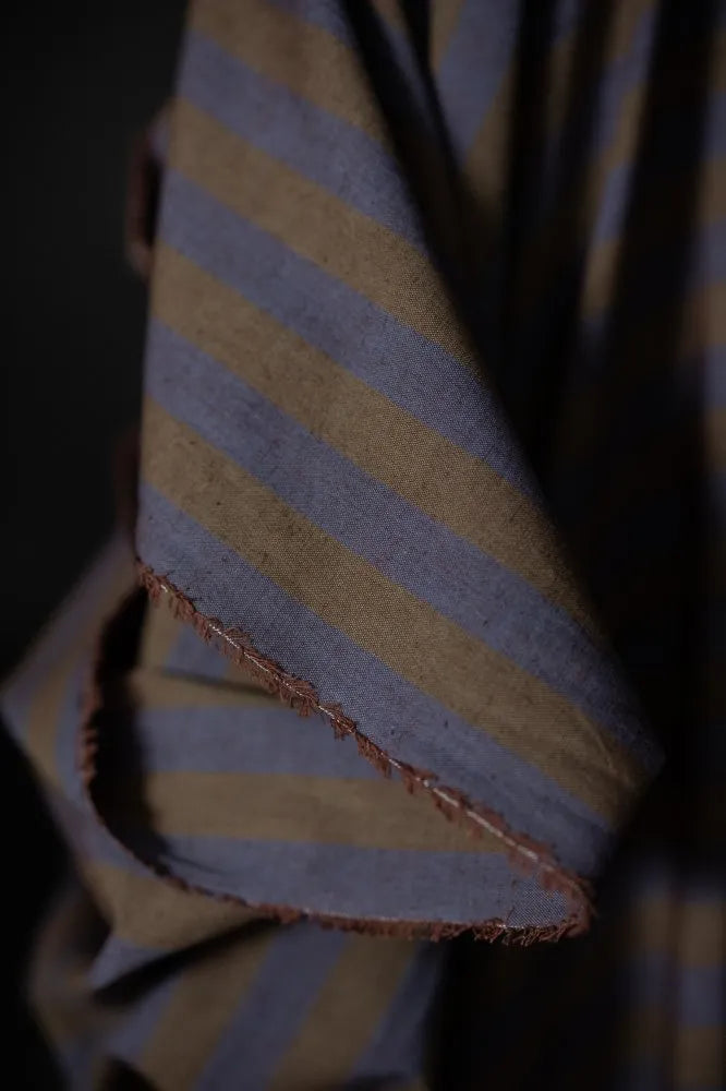 Close-up of a folded fabric with blue and yellow stripes on a dark background