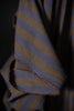 Close-up of a folded fabric with blue and yellow stripes on a dark background