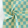 Green and white checkered fabric with a visible brand name.