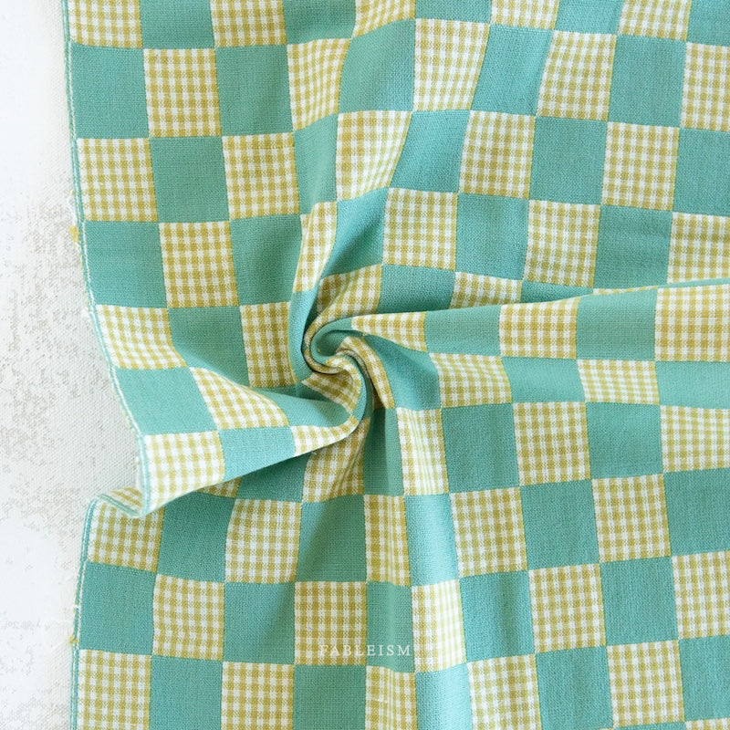 Green and white checkered fabric with a visible brand name.