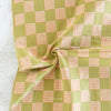 Green and orange checkered fabric on a textured surface