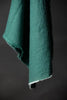 Teal fabric with frayed edges on a dark background