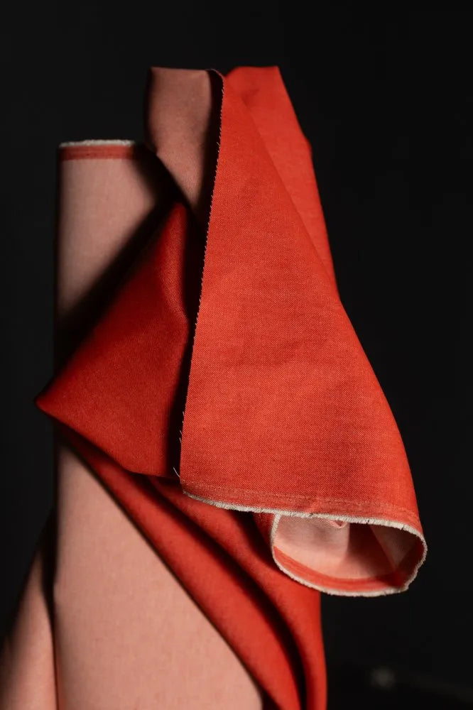 Red fabric draped over a person against a dark background