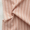 Pink fabric with a subtle pattern on a light gray background