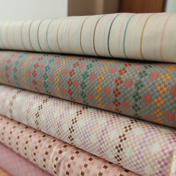Stack of fabric swatches with various patterns and colors.