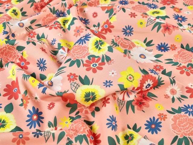 Floral fabric pattern with colorful flowers on a pink background