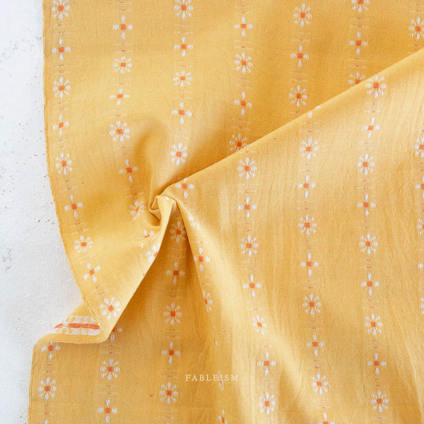 Yellow fabric with small floral pattern on a white background