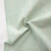 Light green fabric with subtle pattern on a textured surface