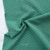 Green fabric with a subtle pattern on a white background, featuring the brand 'Fableism'.