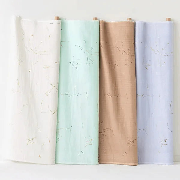 Four folded pieces of fabric, ranging in color from light blue to beige, with a floral pattern, displayed side by side against a white background.