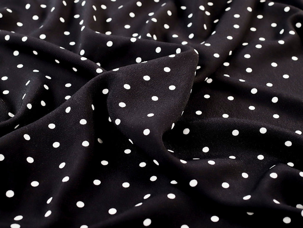 Black fabric with white polka dots