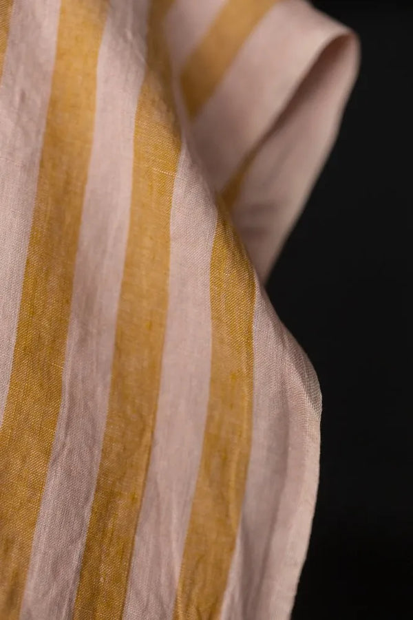 Close-up of striped fabric with yellow and beige colors on a black background
