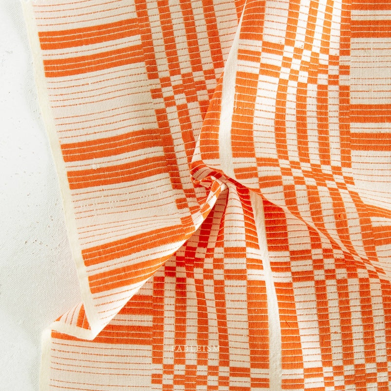Close-up of orange and white checkered fabric on a white background