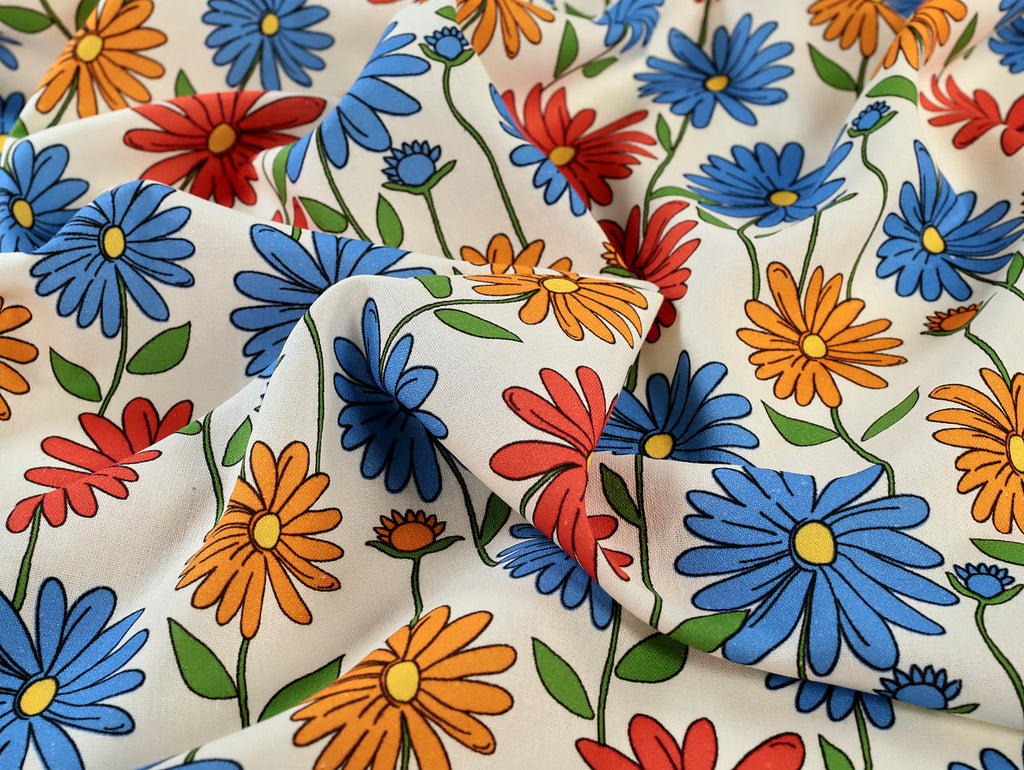 Colorful floral pattern on fabric with blue, red, orange, and yellow flowers.
