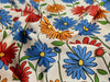 Colorful floral pattern on fabric with blue, red, and orange flowers.