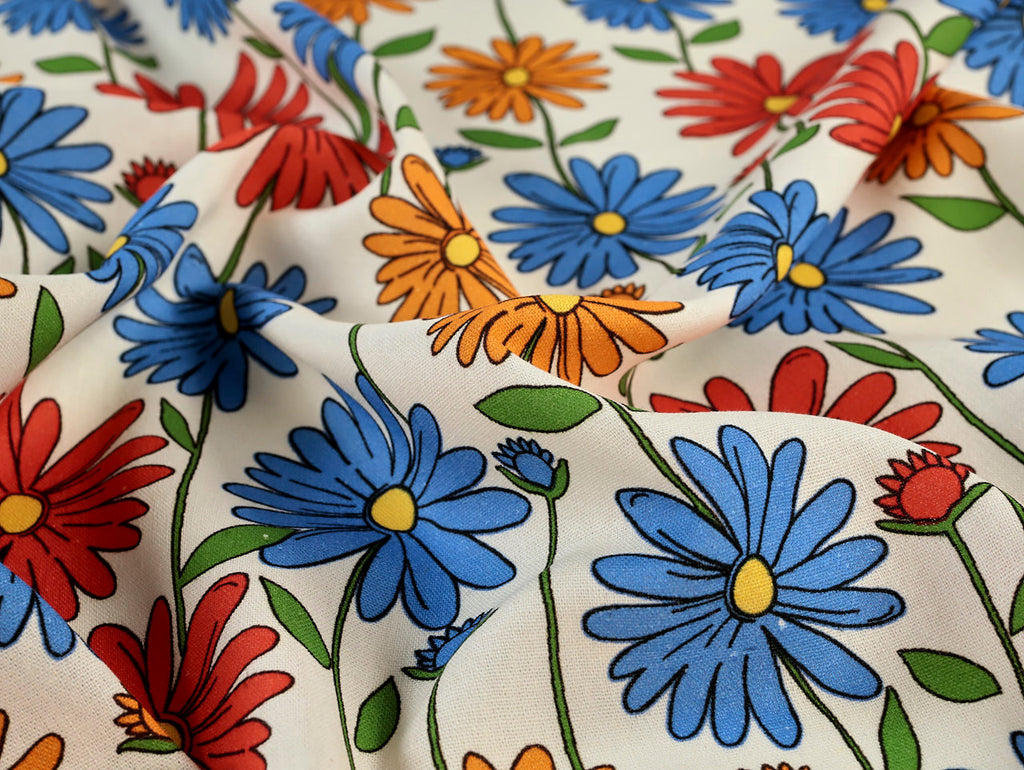 Colorful floral pattern on fabric with blue, red, and orange flowers.