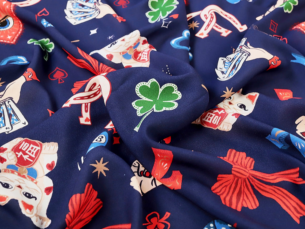 Navy blue fabric with colorful graphics including dogs, leaves, and abstract shapes.
