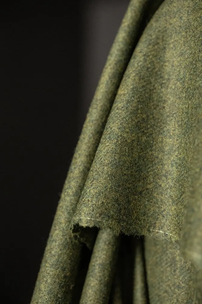Close-up of green fabric with a textured pattern on a dark background