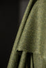 Close-up of green fabric with a textured pattern on a dark background