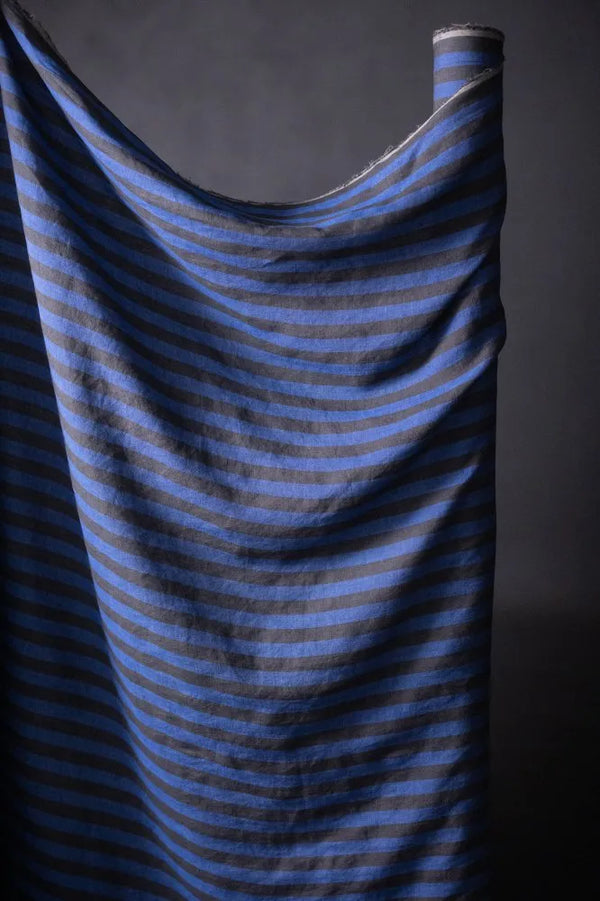 Blue striped fabric draped over a dark background