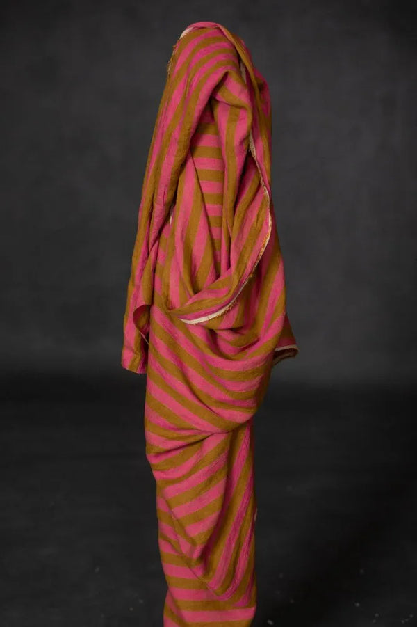 Pink and brown striped fabric draped over a black background