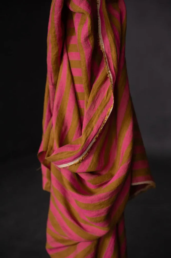Pink and brown striped fabric draped over a black background