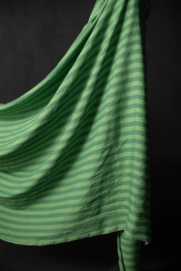 A wide stripe linen fabric in two shades of bright green, displayed on a dark background.