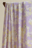 Floral patterned fabric draped over a wooden rod against a beige background