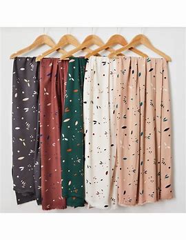 A selection of crepe fabric swatches in various colors, including green, brown, beige, and pink, featuring a floral pattern.