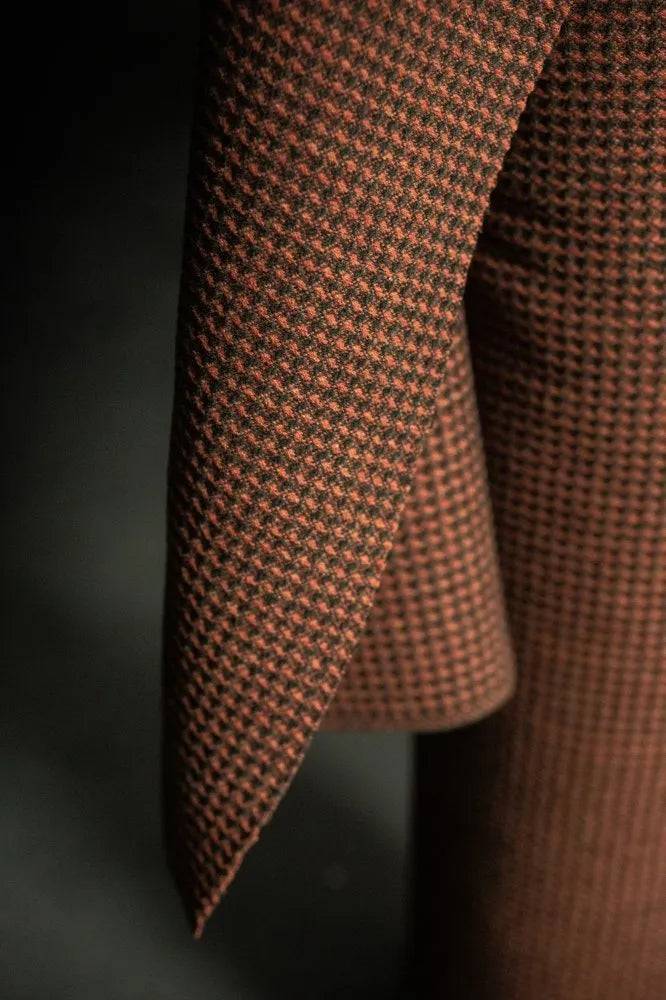 Close-up of a brown houndstooth patterned fabric on a dark background