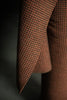 Close-up of a brown houndstooth patterned fabric on a dark background
