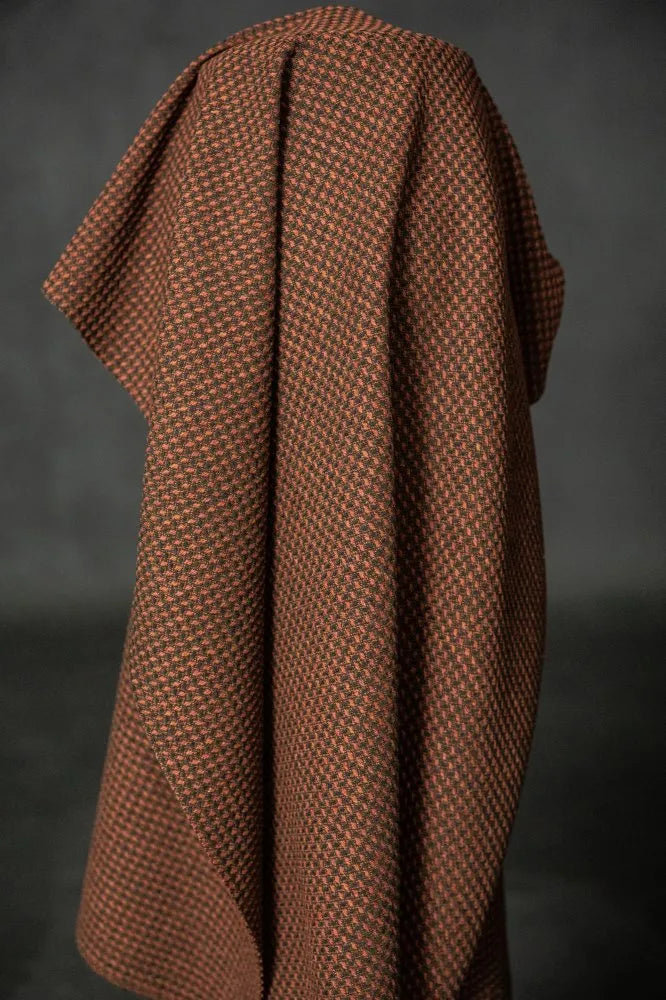 Brown textured blanket draped over a dark background