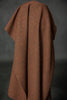 Brown textured blanket draped over a dark background