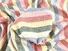 Multicolored striped fabric with shades of pink, blue, green, and beige.