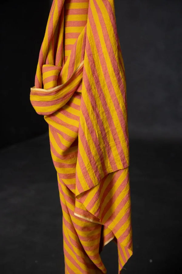 Yellow and red striped fabric draped over a black background