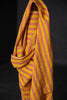Yellow and pink striped fabric draped over a black background