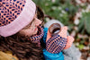 Person drinking from a coffee cup outdoors with a blurred natural background