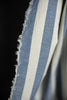 Close-up of blue and white striped fabric with frayed edge on a black background