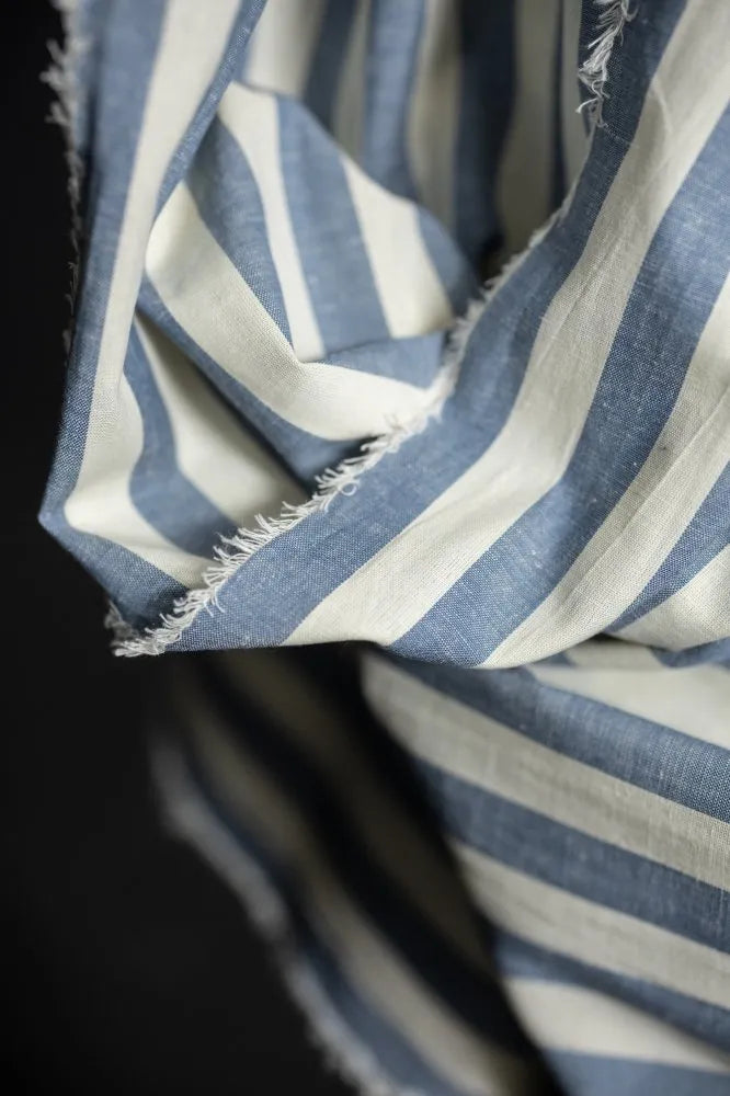 Close-up of a blue and white striped fabric with a dark background