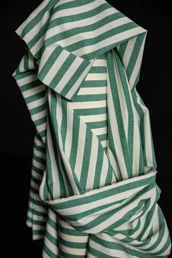 Green and white striped fabric on a black background