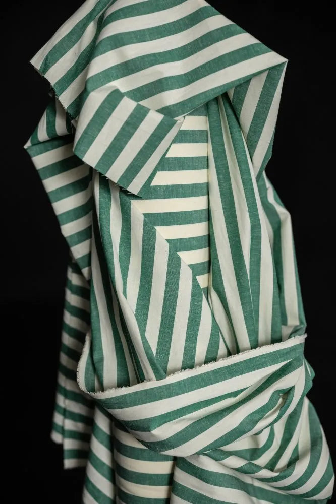 Green and white striped fabric on a black background