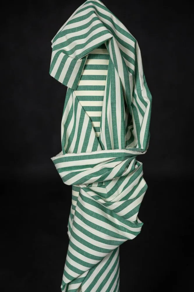 Green and white striped fabric on a black background