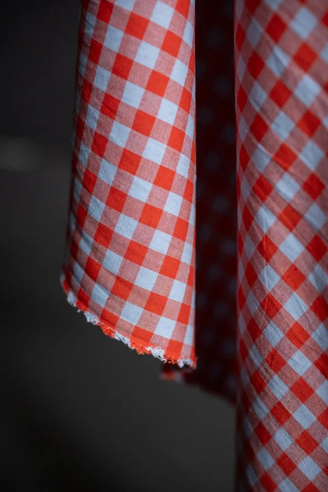 Close-up of red and white checkered fabric against a dark background