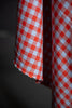 Close-up of red and white checkered fabric against a dark background