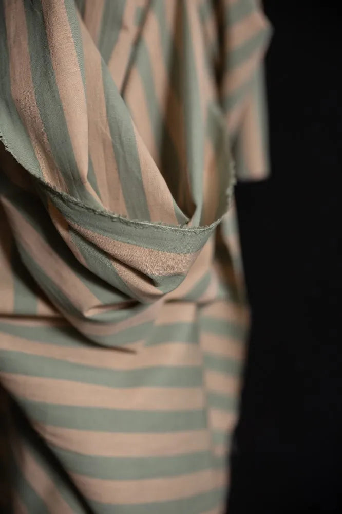 Close-up of a striped fabric with green and brown colors on a black background